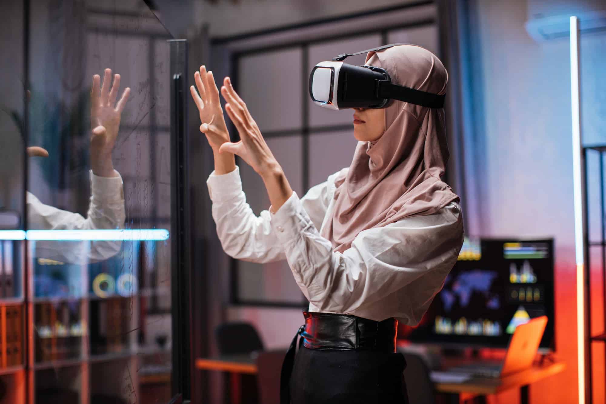 Confident muslim woman in hijab using innovative technology during business strategy.