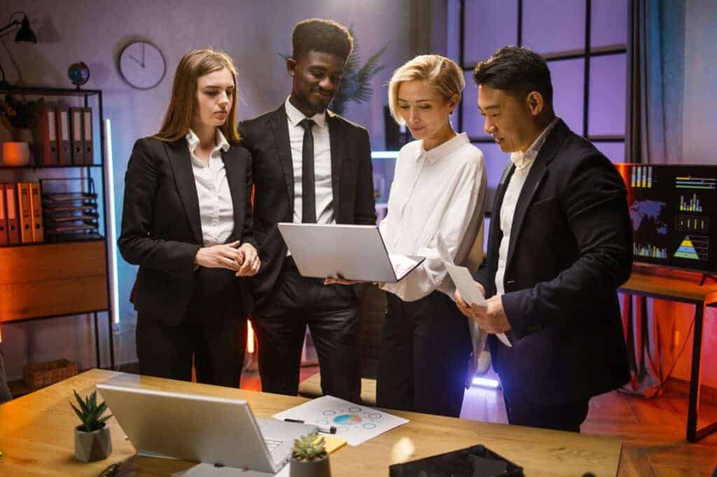 Four colleagues brainstorming at dark office