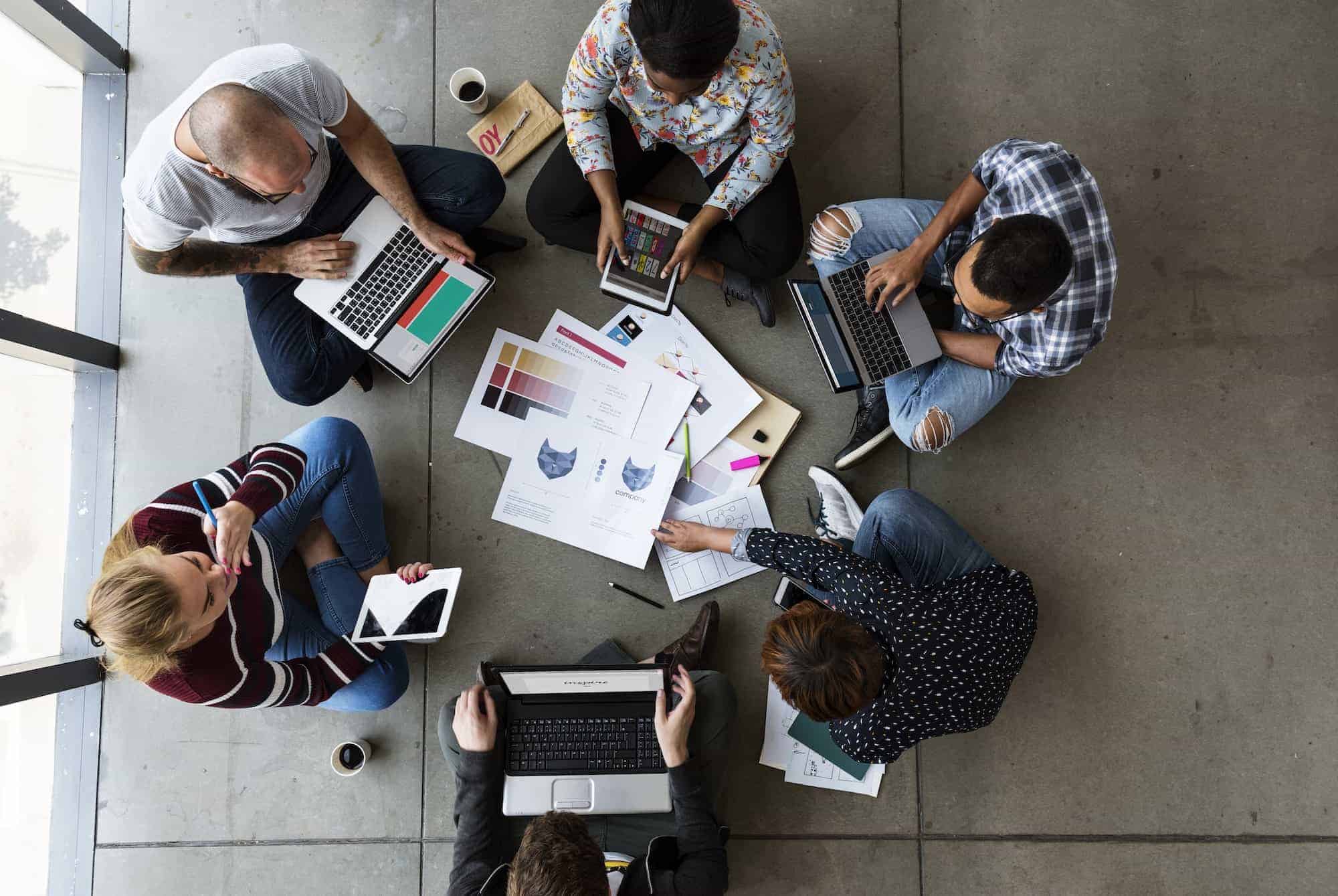 Group of people brainstorming sitting on the floor