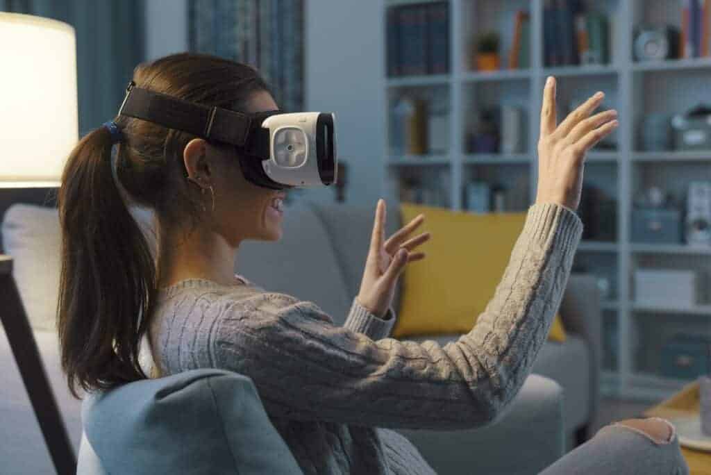 Woman relaxing on the sofa and interacting with virtual reality